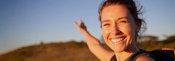 A happy woman smiling outside.