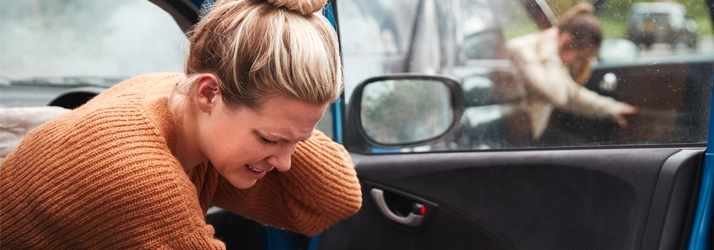 Two woman holding their necks after a car accident.